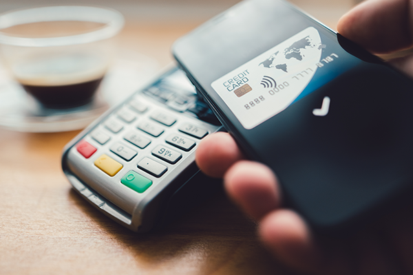 Bitcoin ATM - Hand Holding an Phone With Credit Card and Scanner