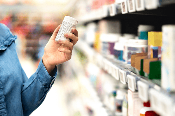 Person Shopping for Health and Beauty Products Holding Advil Pills